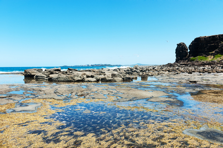 Rocks along the coastline under blue skyの写真素材