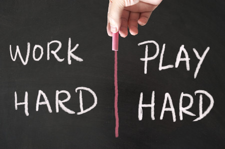 Work hard and play hard words written on blackboard using chalkの写真素材