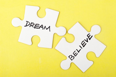Dream or believe words on two pieces of jigsaw puzzleの写真素材