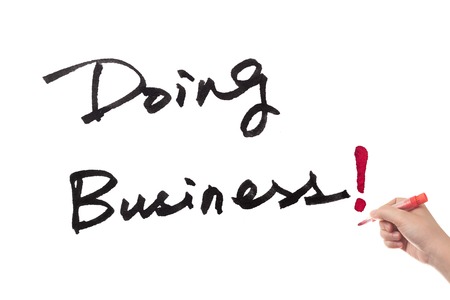 Doing business words written on white paperの写真素材