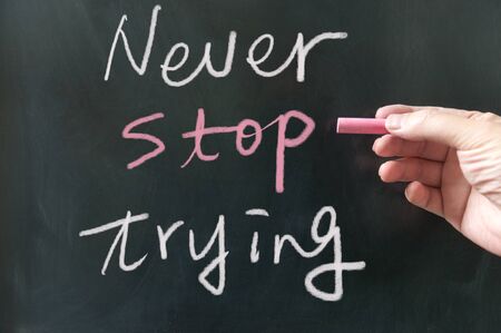 Never stop trying  words written on blackboard using chalkの写真素材