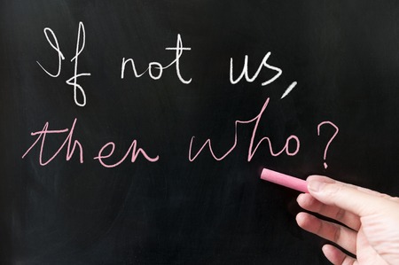 If not us then who words written on blackboard using chalkの写真素材