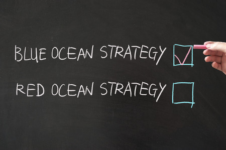 Blue or red ocean strategy words written on the blackboard using chalkの写真素材