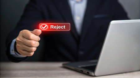 Businessman hand holding a check mark button on the screen of laptopの素材
