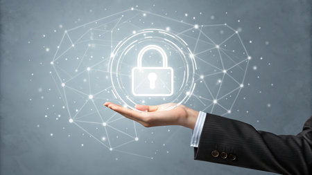 Businessman hand holding a glowing padlock on a gray wall backgroundの素材