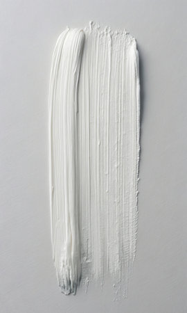 White paint brush strokes on a white background, close-up.の素材