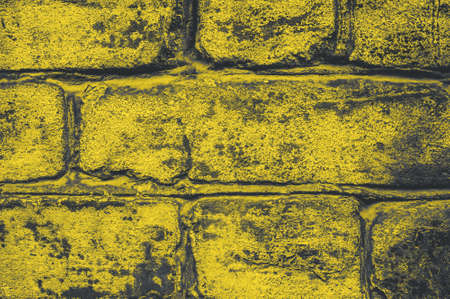 Surface of grunge brick wall painted in trendy illuminating yellow color of the year 2021の写真素材