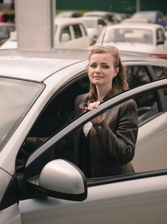 happy smiling girl standing near the car.