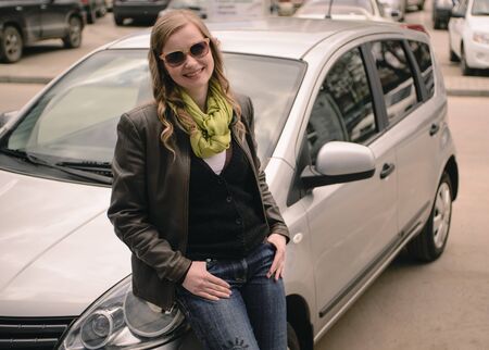 happy smiling girl standing near the car.
