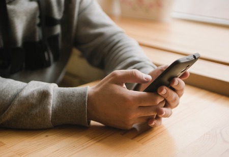 young man uses the phone in a cafe