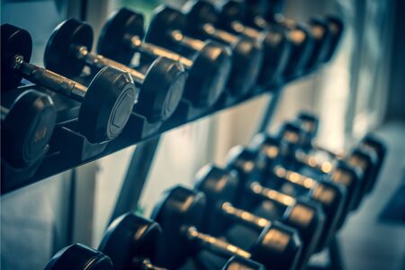 Black dumbbell set. Close up many metal dumbbells on rack in sport fitness center , Weight Training Equipment concept.の写真素材