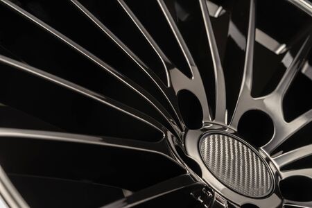 new Luxury Black alloy Wheel, sporty with thin spokes, close-up on black backgroundの写真素材