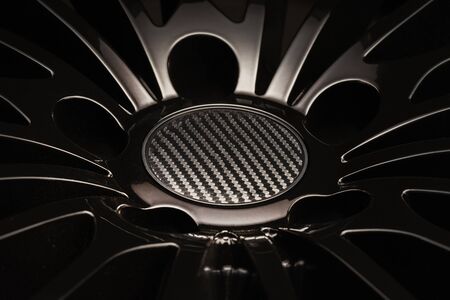 new Luxury Black alloy Wheel, sporty with thin spokes and carbon cap, close-up on black background.の写真素材