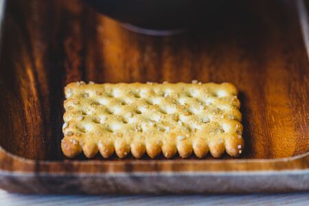 dry salted cracker on a wooden tray. close up