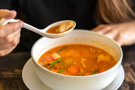 Girl eating Tom Yam Kung, Thai cuisine. close upの写真素材