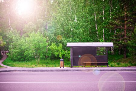Bus stop near the road in the forest. Green background.の写真素材