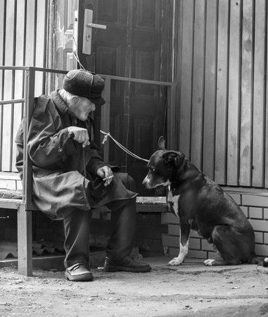 old sad lonely grandpa talking to his dog. black and white photo.のeditorial素材