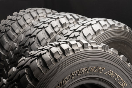 Krasnoyarsk, Russia 20 august 2019: four off-road tires on black background. close up.のeditorial素材