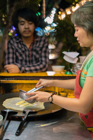 Khaolak, Thailand, 5 june 2019: ute Thai woman cooking and selling traditional Thai sweet pancakes Roti on the street of Khao Lak in Thailand.のeditorial素材