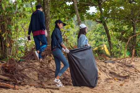 Khao Lak, Thailand, 1 june 2019: People of different nationalities cleaning garbage on the black beach to clean the beach in the world environment, volunteer concept.のeditorial素材