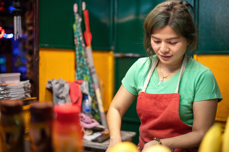 Khaolak, Thailand, 5 june 2019: Thai girl seller sells fruit, bananas, mangoes, tangerines and pineapples in a convenience store on Khao Lak streetのeditorial素材