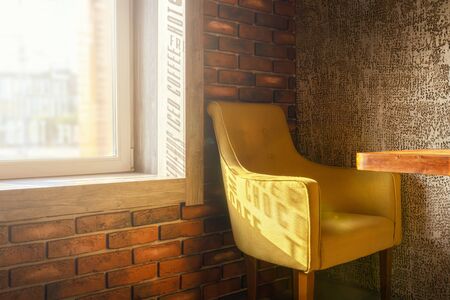 shade the word shoco from the lettering on the window on the light green chair by the window in the coffee shop. beautiful and stylish interior of the coffee shop, brick loftの写真素材