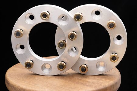 Automotive parts - close up new stainless metal remote adapter spacer wheel hub of the car on black...