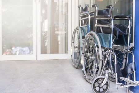 wheelchair are fold and park in the hospital entrance, Medical equipment for use as a means of transport by a person who is unable to walk as a result of illness, injury, or disability, copy space.の写真素材