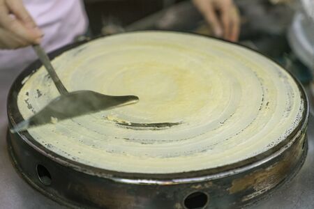 roll out the dough evenly and gently on the hot pancake pan surface, cooking processの写真素材