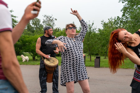Krasnoyarsk, Russia, June 30, 2019: an adult female freak dances to African Tam Tam drums in a public Park. partyのeditorial素材