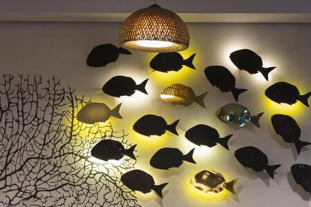 unusual lamps on the wall in the form of a floating school of fish . Beautiful interior design. the...