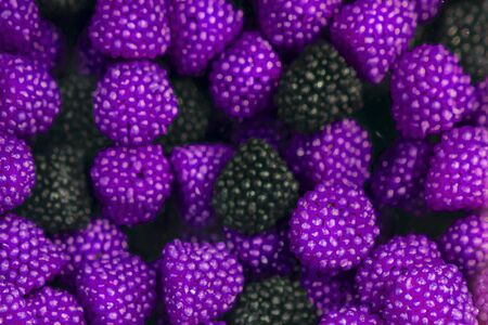 Assorted gummy candies, raspberry and BlackBerry shaped candies. The view from the top. Sweet background, bright violet and black colorの写真素材