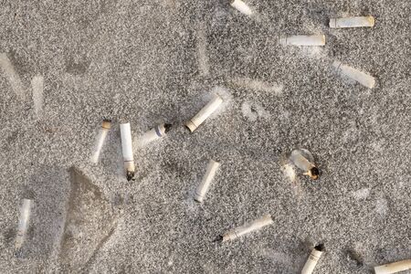 cigarette butts on the gray snow, powdered with frost. sry dark backgroundの写真素材