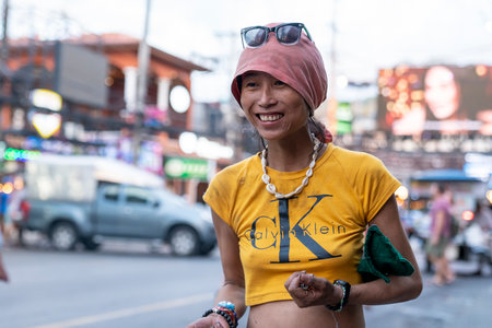 Thailand, Phuket, April 15, 2020: A Thai woman in a yellow t-shirt smiles on the street. Untidy appearance and inappropriate behavior.のeditorial素材