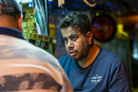 Thailand, Phuket, March 30, 2020: a bearded adult man on a street in Thailand is talking to another...