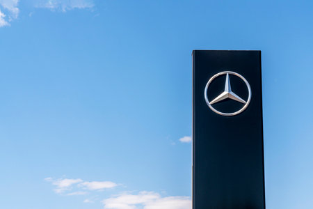 Krasnoyarsk, Russia, may 22, 2020: Mercedes Benz company logo on a blue sky background. Branded advertising rack near the dealershipのeditorial素材