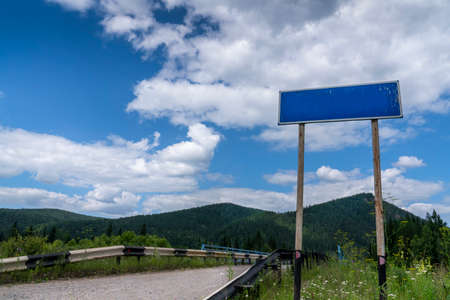 empty road blue country sign pointer on the background of beautiful nature, sky and mountains....