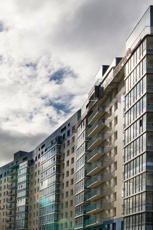 Krasnoyarsk, Russia, August 10, 2020: residential building with balconies against the dark sky, on the edge of the forest. Modern eco-friendly area for housing.のeditorial素材