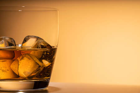 glass of whiskey on the rocks close-up. or other alcohol: Bourbon, cognac, or liqueur. Orange...
