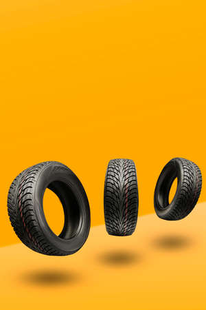 three winter tires friction  on a bright orange background. seasonal change of wheels for winter....