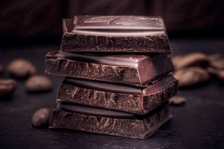 dark chocolate close-up pieces of cubes on the table. black background, candy.の写真素材