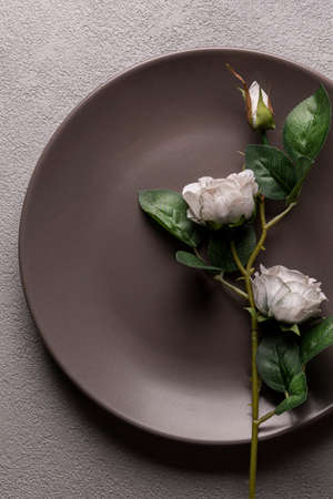 a brown plate with a rose on it, close-up. The beginning of a beautiful love story, hints and detailsの写真素材