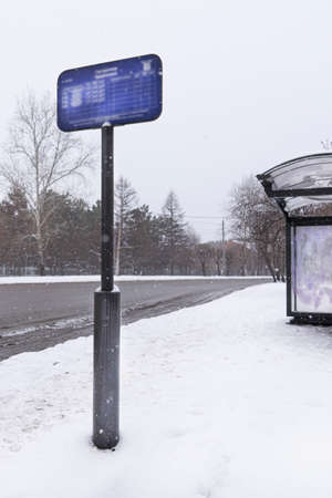 bus and transport stops in the suburbs or villages near the forest. A sign with a bus schedule. vertical photoの写真素材