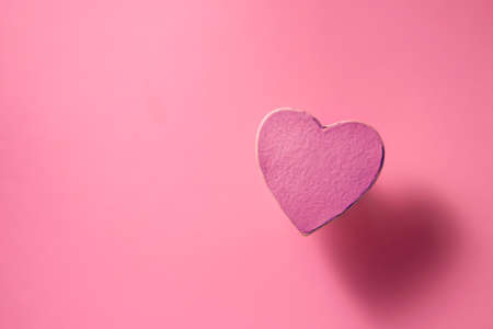 a heart on a pink background and a shadow from it, soft lightsの写真素材