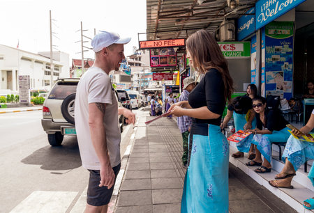 a white man arranges with a Thai masseuse for a Thai massage session on the red light street of Bangla Road in Thailand, thailand, Phuket, December 31, 2019のeditorial素材