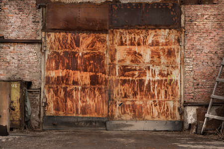 rusty big gates of an industrial abandoned garage, brick wallsの写真素材