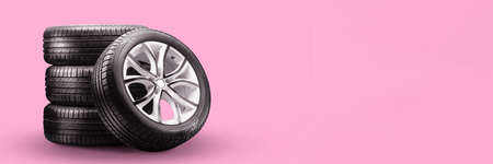 summer tires and wheels-stack on pink background, new wheels long blank layout copyspaceの写真素材