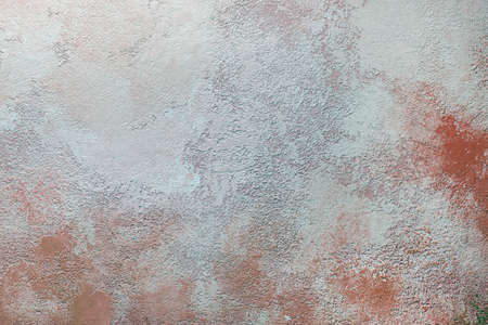 the background is a dirty wall. Stains and red streaks on the old textured plaster of the wall