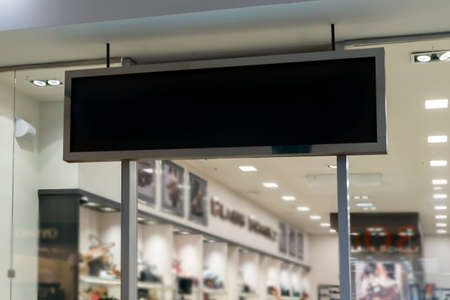 a black mockup sign over the entrance to a clothing store. empty space, layout for advertising...