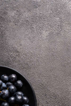 Flatlay texture plate with plums. empty space copy space, gray concrete background. a concept for a...